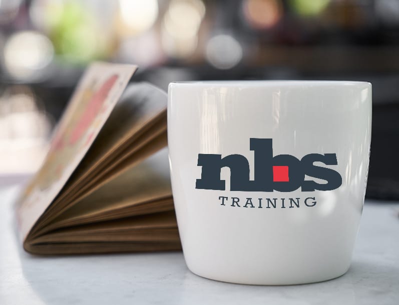 A coffee mug with the NBS Training logo upon it